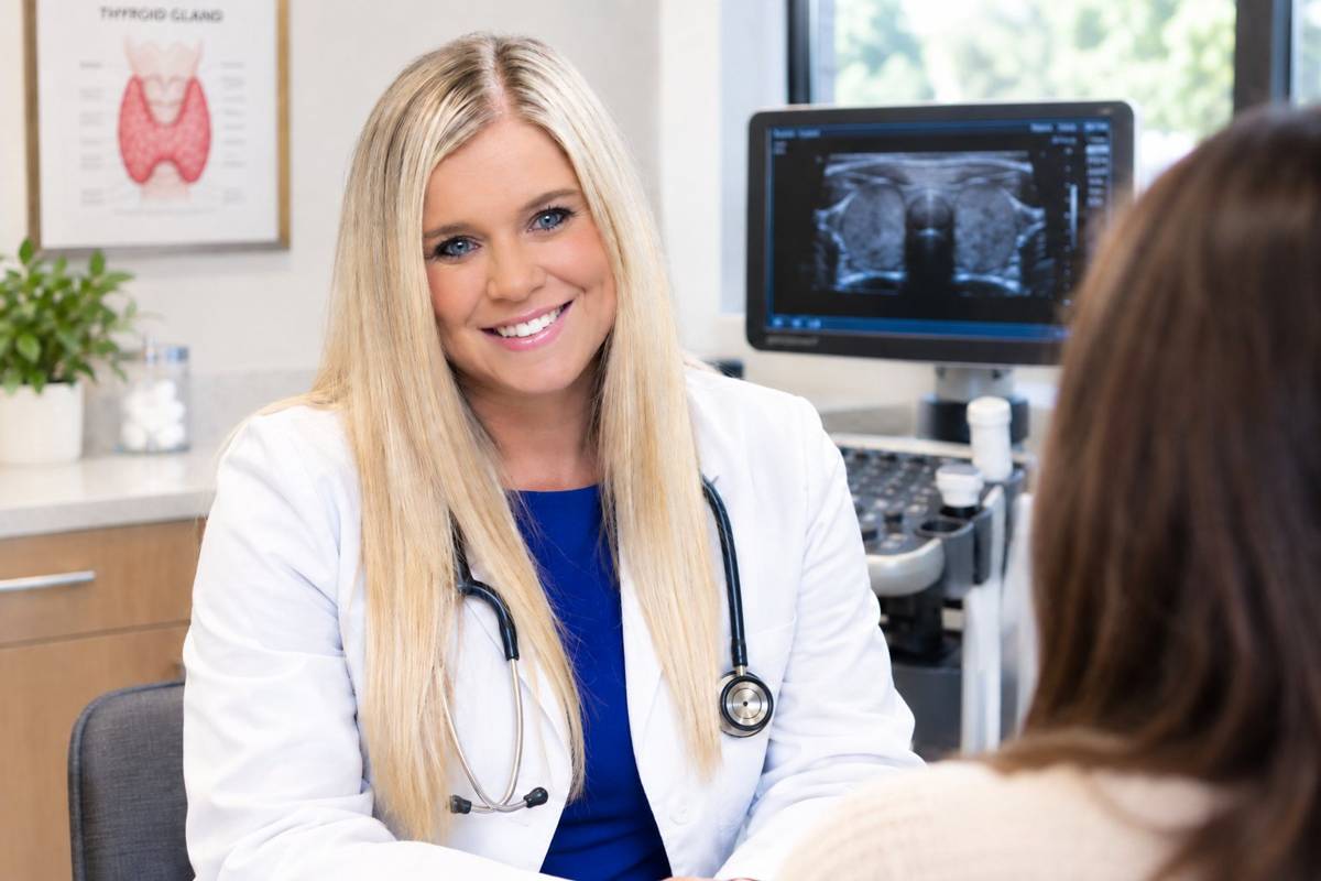 Dr. Henderson smiling with a patient beside a thyroid ultrasound